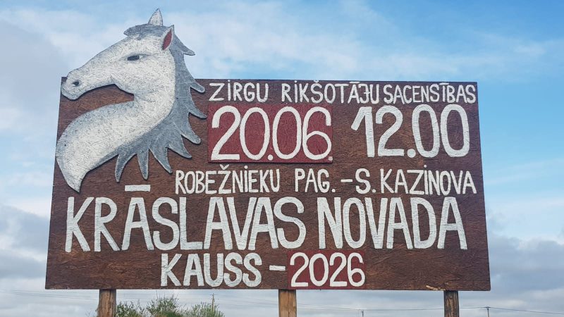 Koka ceļmalas plakāts ar baltu zirga galvas attēlu un informāciju par rikšotāju sacensībām.