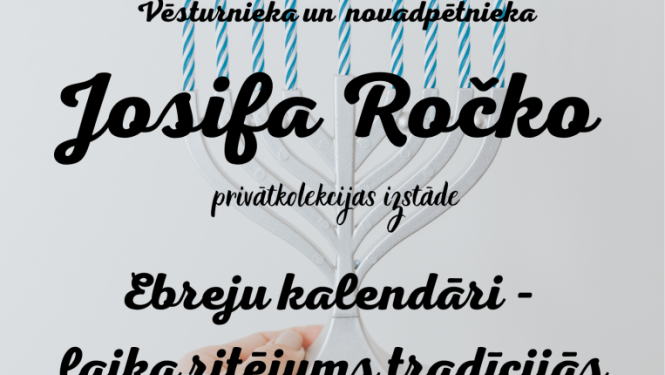 Roka baltā džempera piedurknē tur baltu deviņzaru svečturi ar zilām degošām svecēm