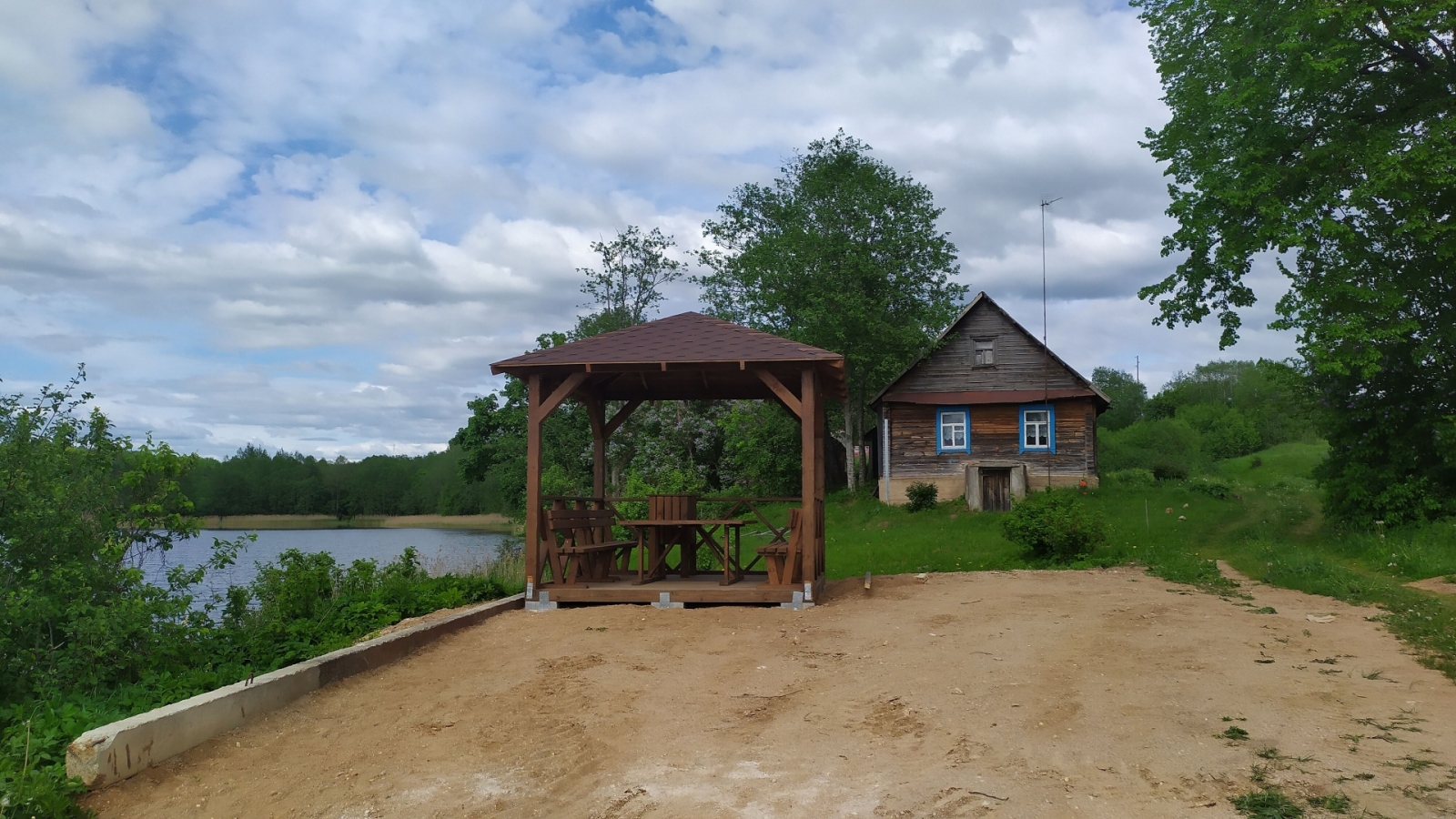 Koka lapene ar koka galdu un soliņiem uz Daugavas fona