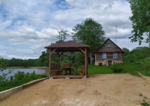 Koka lapene ar koka galdu un soliņiem uz Daugavas fona