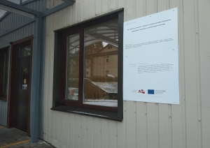 Piestiprināta projekta plāksnīte pie slimnīcas sienas