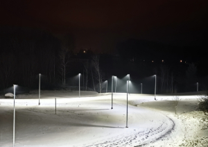 Apgaismots, sniegots stadions rindā izvietotiem laternu stabiem
