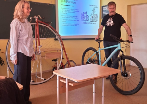 Klasē skolotāji demonstrē dažādus velosipēdus prezentācijas laikā.