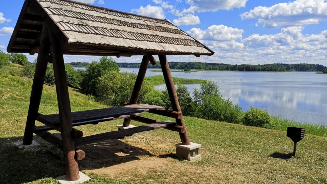 Koka galds ar jumtu ezera krastā