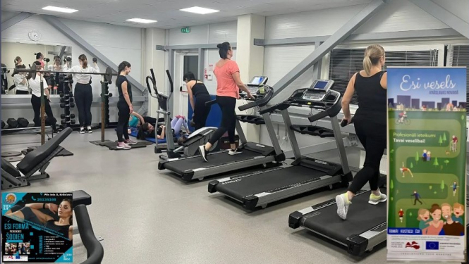 Cilvēki trenējas sporta zālē