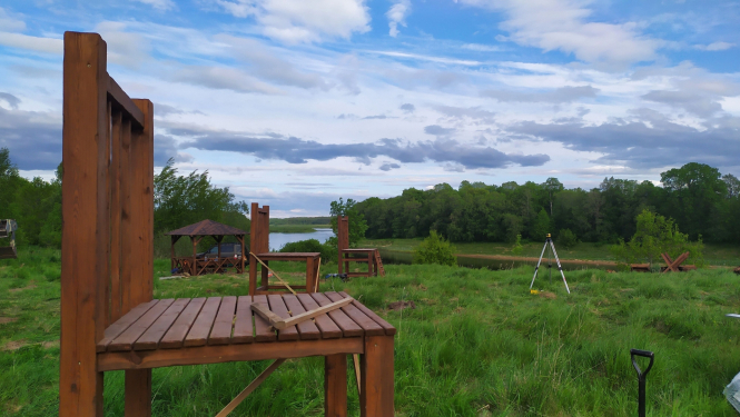 Lieli koka krēsli uz Daugavas fona