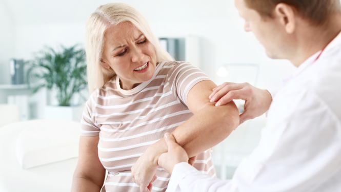 Ārsts apskata sievieti, kurai sāp roka