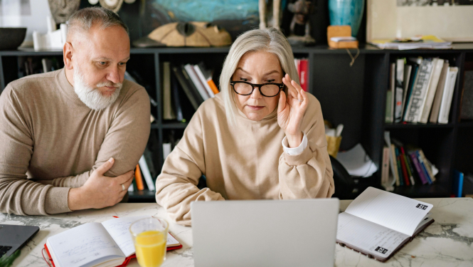 Divi seniori lieto klēpjdatorus un piezīmju klades