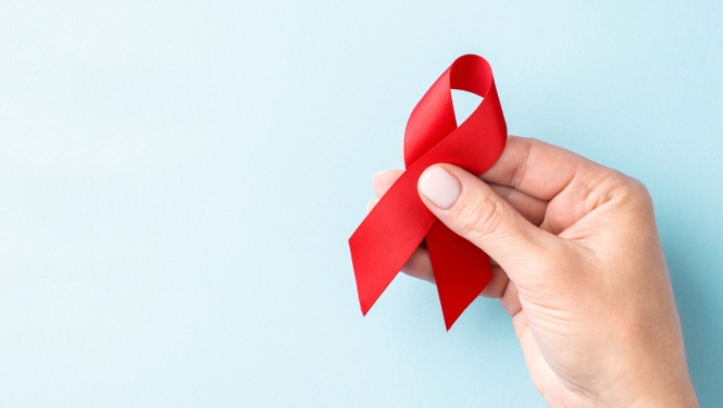 Cilvēks tur rokās sarkanu lentīti