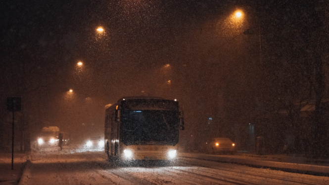 Autobuss brauc pa ceļu tumšā diennakts laikā, ziemā