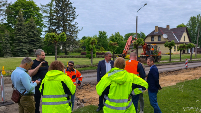 Cilvēki stāv pie ceļa remontdarbiem
