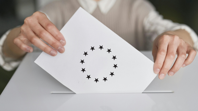 Cilvēks liek aploksni baltas kastes caurumā