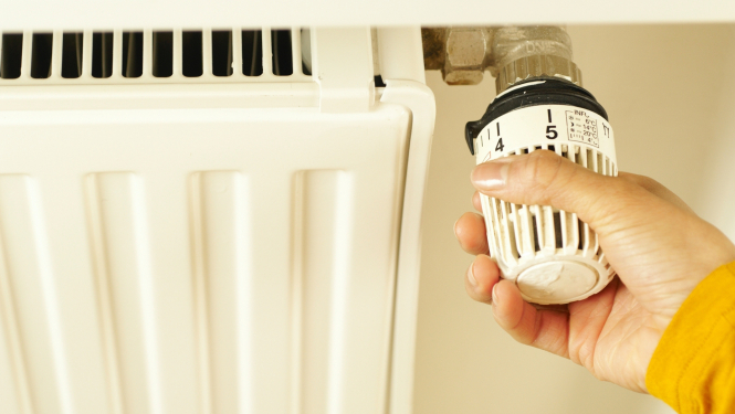 Sievietes roka maina radiatora režīmu