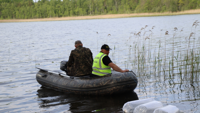 Divi vīrieši laivā uz ezera