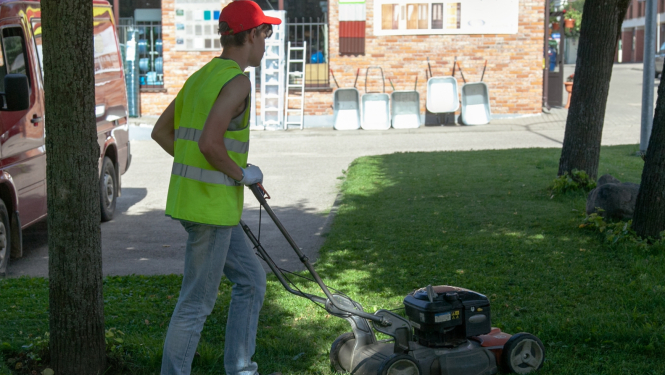 Puisis ar zāles pļāvēju pļauj zāli
