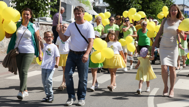 Daudz cilvēku ar baloniem rokās piedalās gājienā Krāslavā