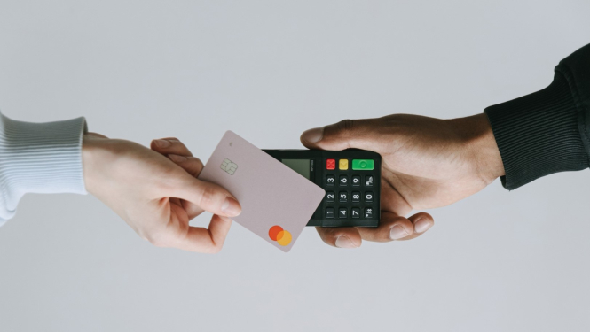 Cilvēks veic apmaksu ar bankas karti