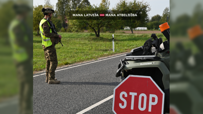 Zemessargs stāv savā postenī. Uzraksts uz foto: "Mana latvija – mana atbildība"