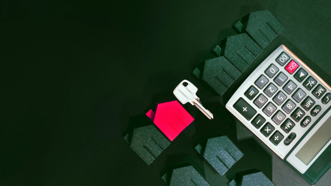 Spēļu mājiņas, atslēga un kalkulators guļ uz galda