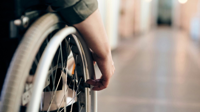 Cilvēks ratiņkrēslā gaitenī