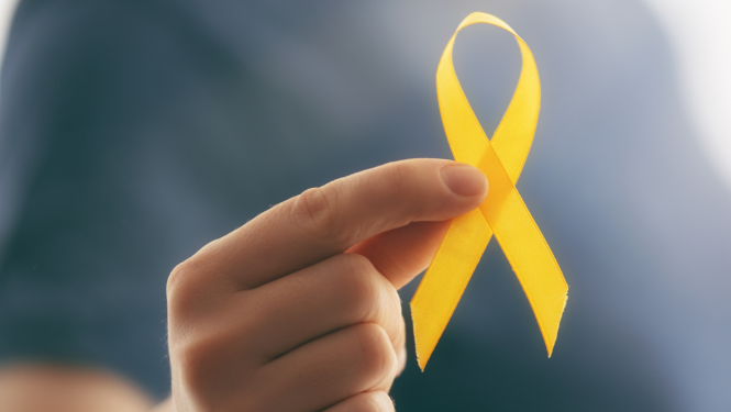 Cilvēks tur rokās dzeltenu lentīti