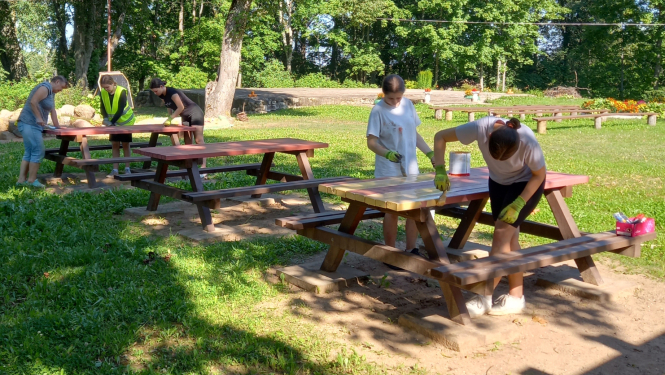 Sievietes krāso brīvdabā esošos galdus