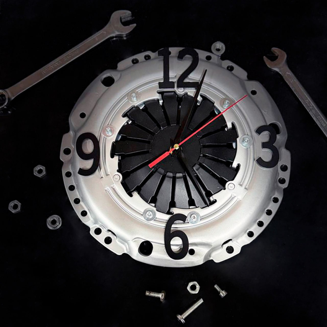 Balts industriāls sienas pulkstenis no sajūga mehānisma ar melniem cipariem