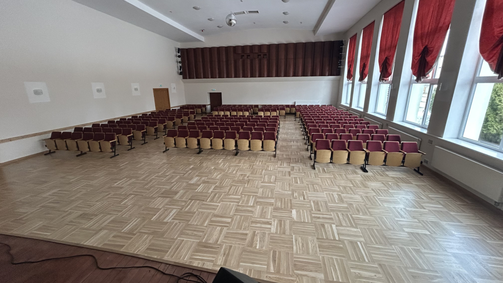 Skats no skatuves uz auditoriju un parketa grīdu.