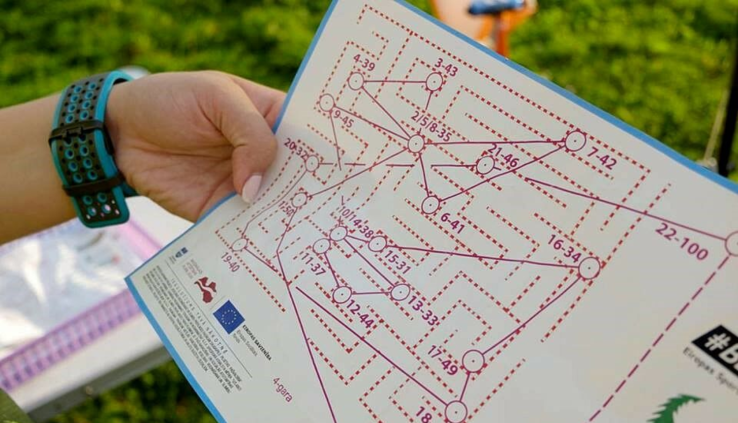 Cilvēks tur rokās orientēšanās karti