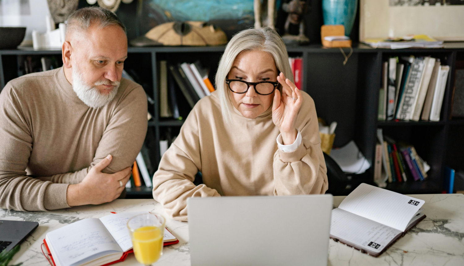 Divi seniori lieto klēpjdatorus un piezīmju klades