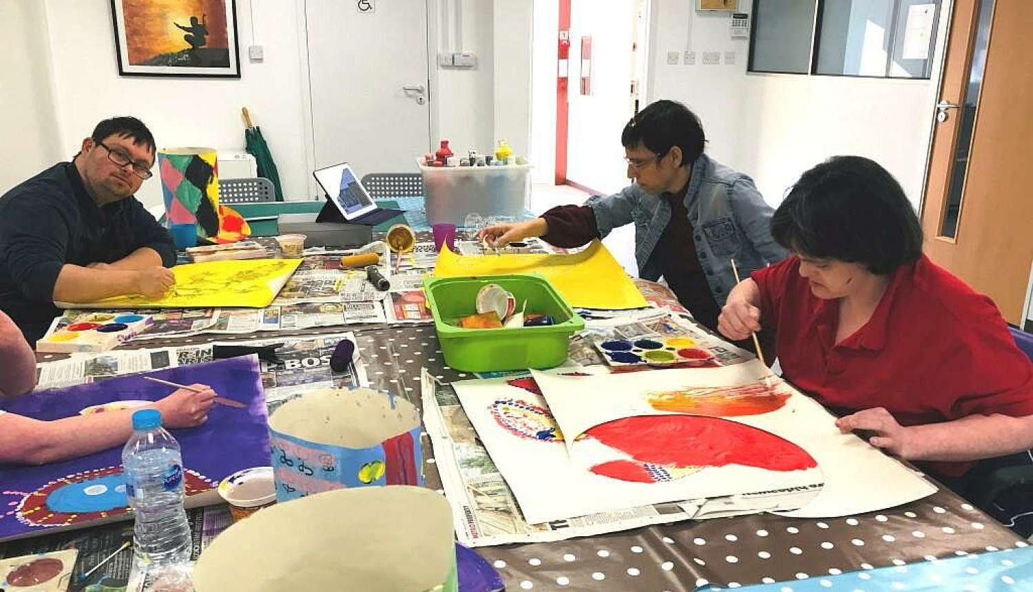 Četras personas ar invaliditāti pie galda glezno