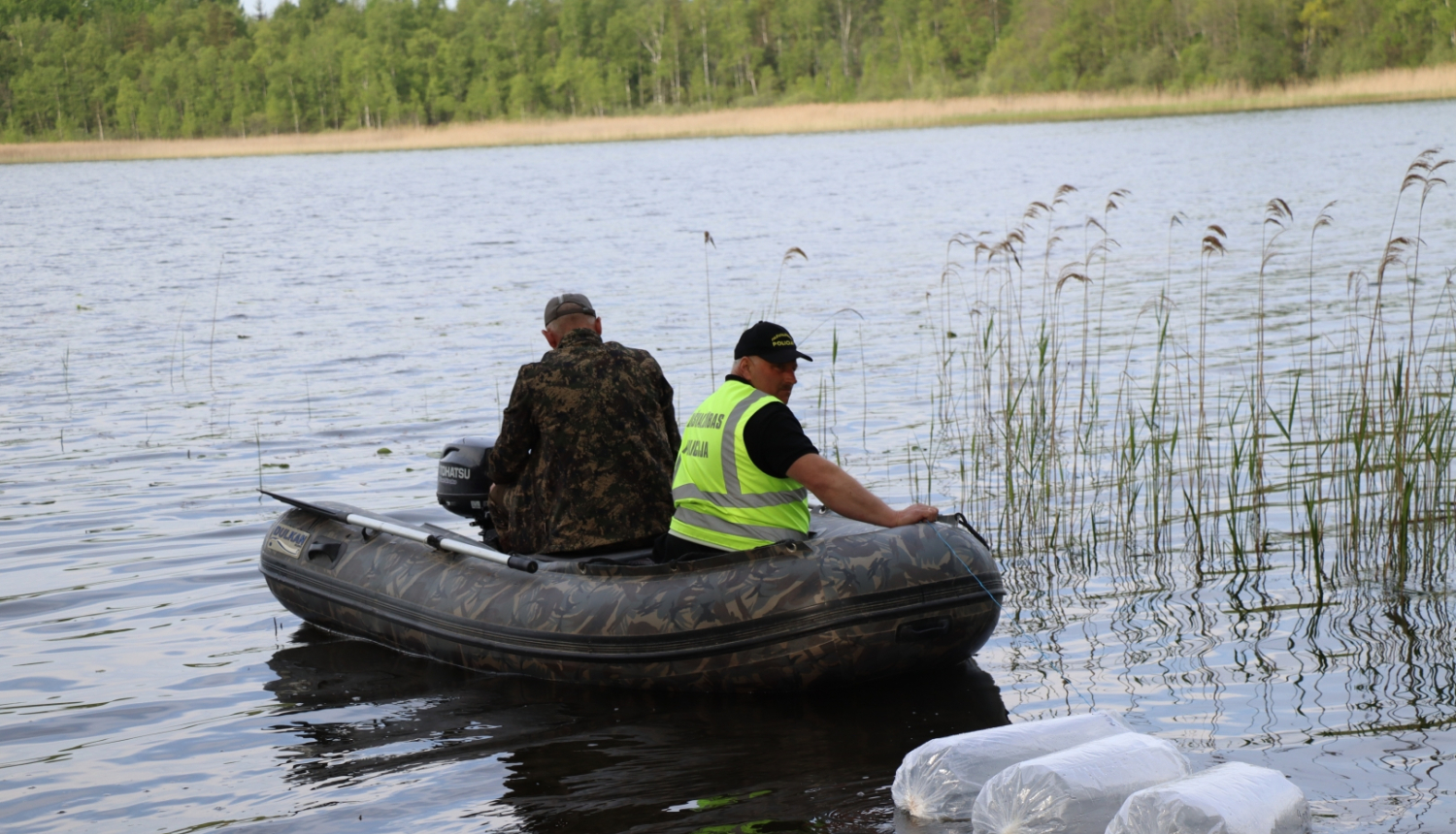 Divi vīrieši laivā uz ezera