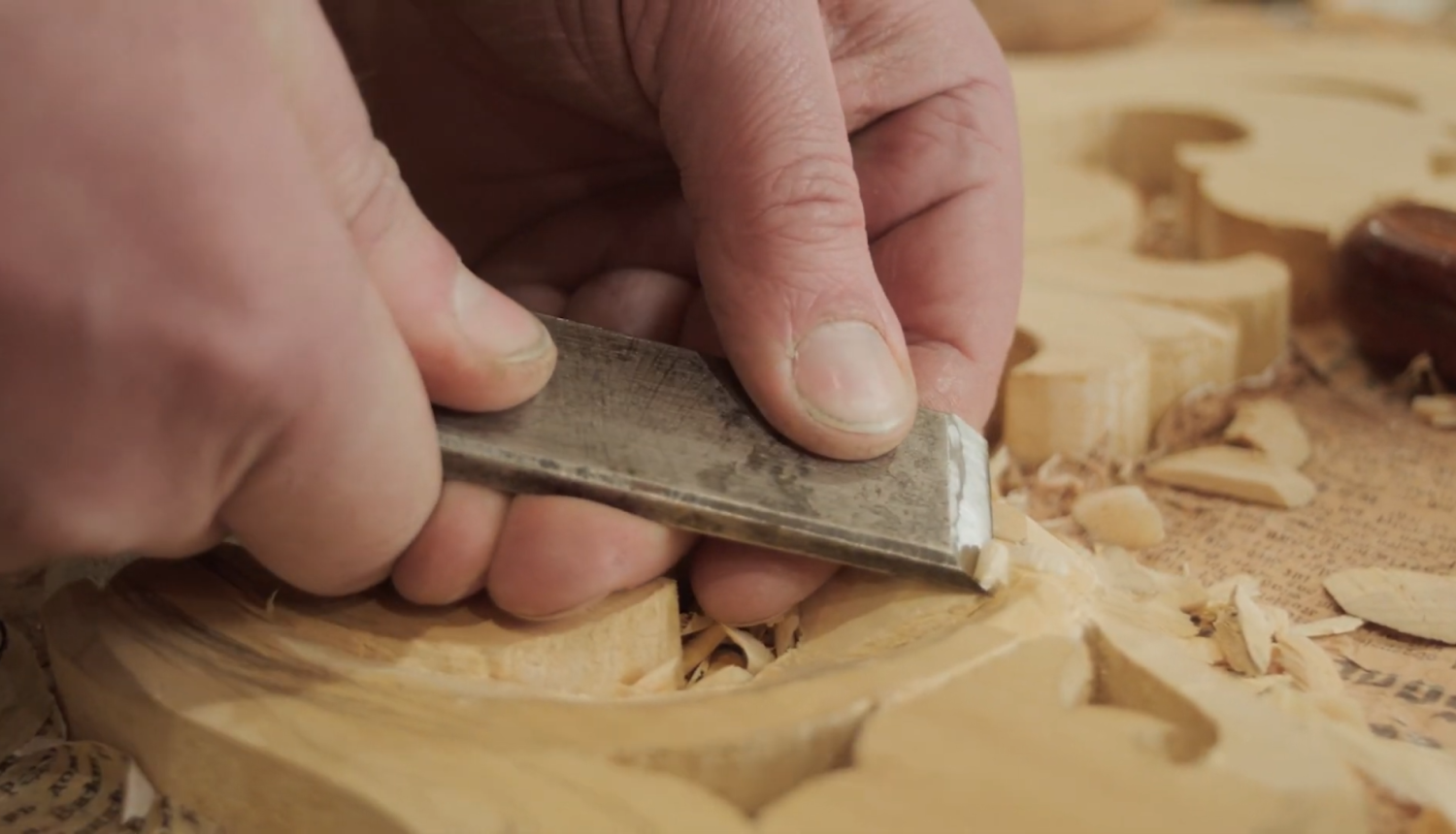 Vīrietis ar kaltu apstrādā koku