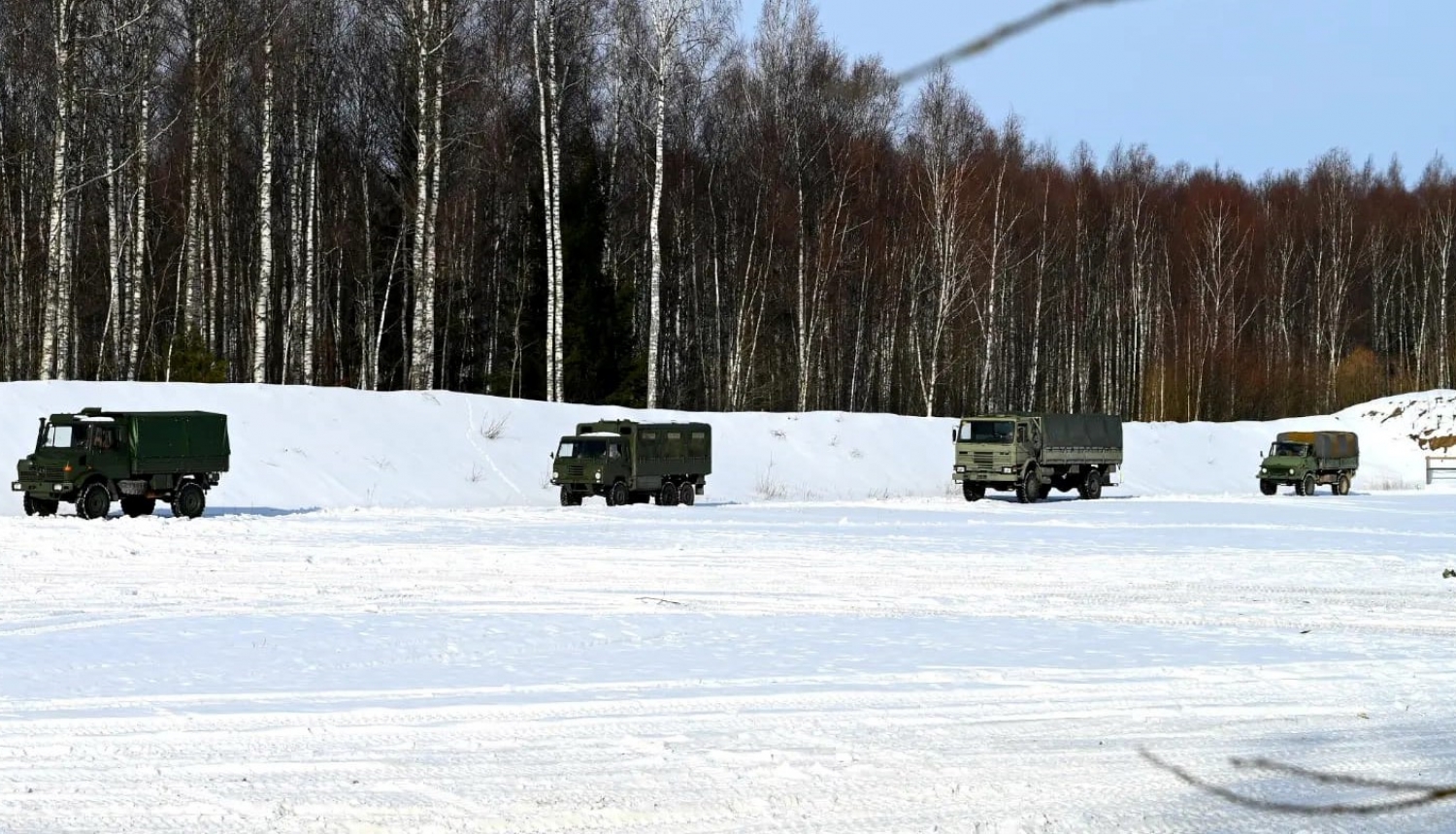 Zemessardzes autotransporta konvojs brauc pa ceļu ziemā